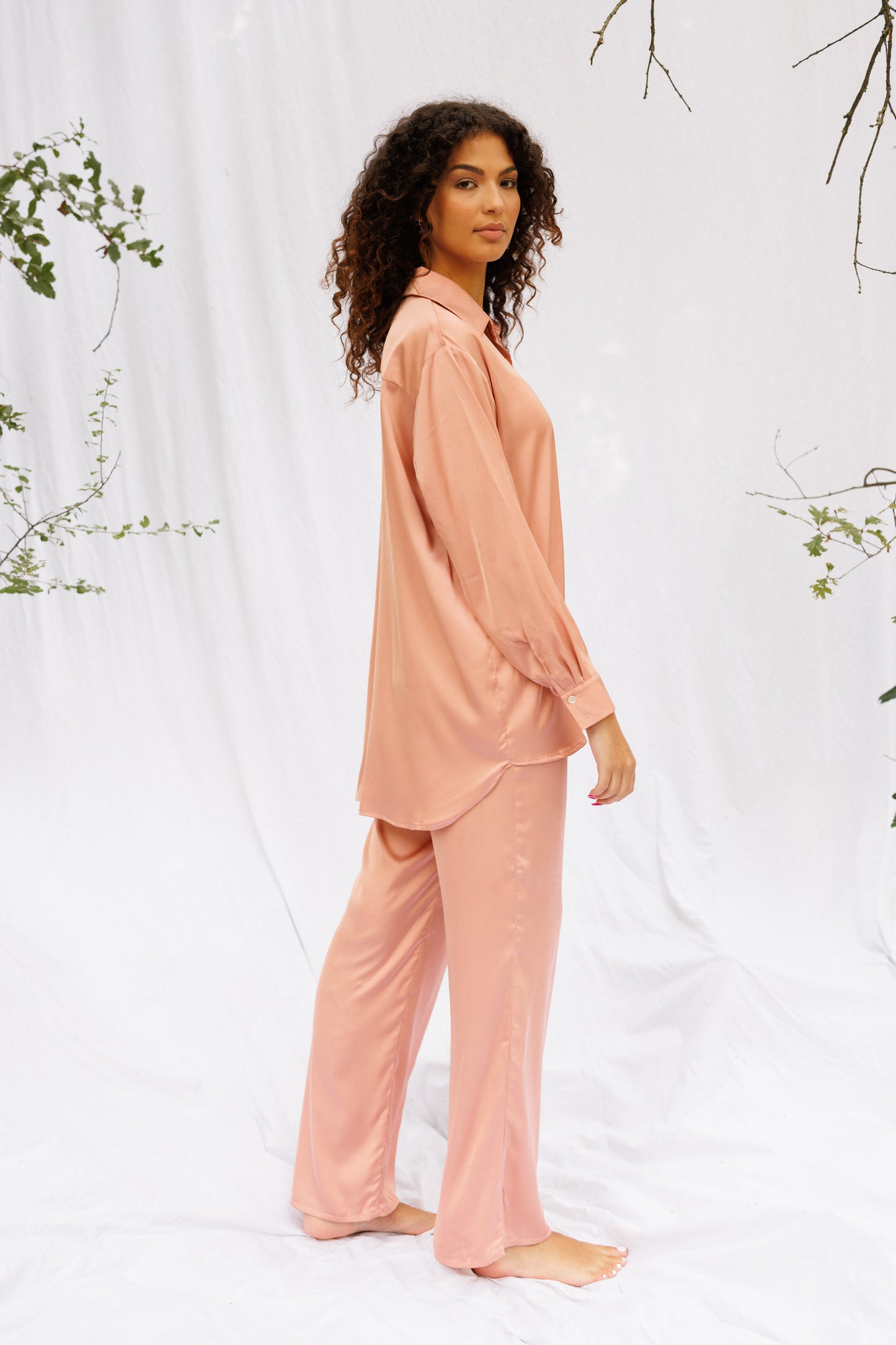 Side picture of Maria wearing a set of synthetic pink pyjamas