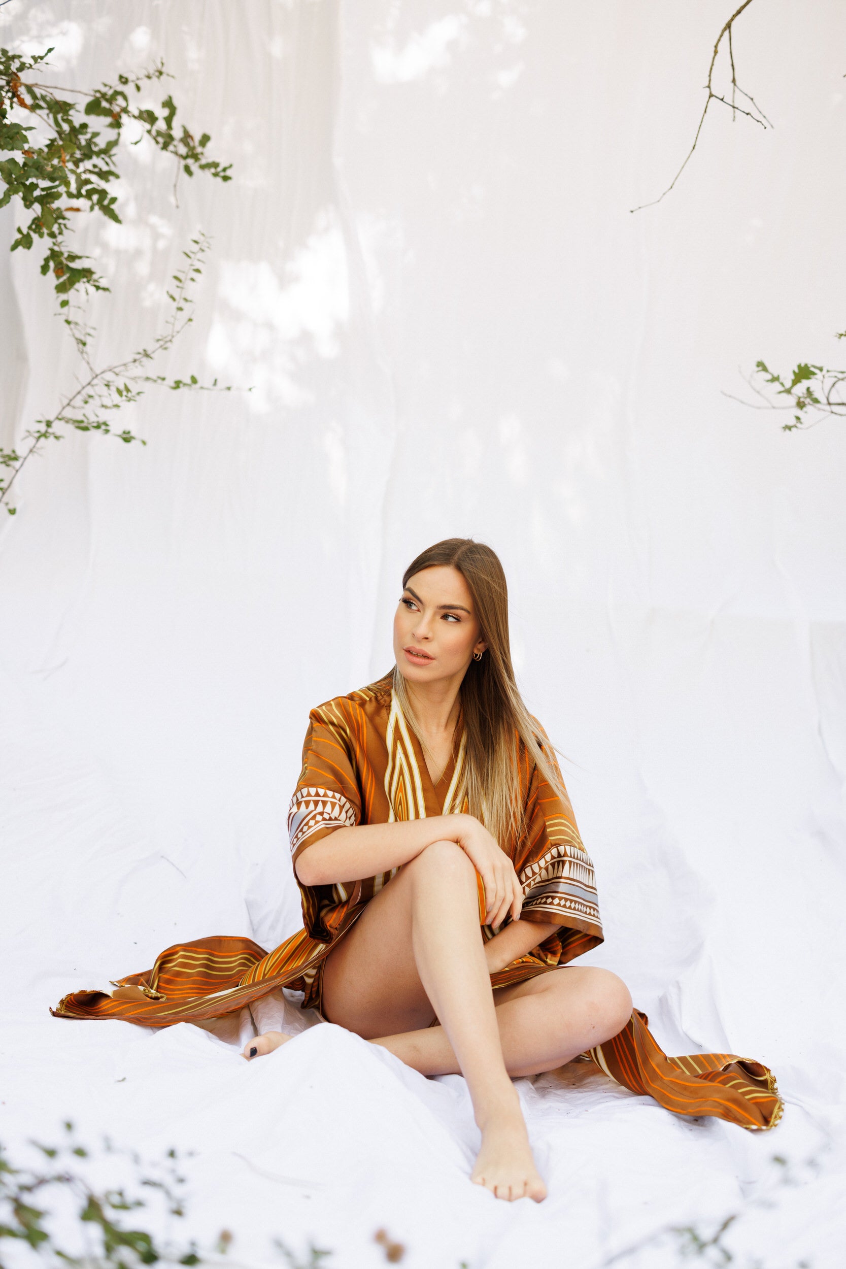 Vayia sitting in a brown silk caftan