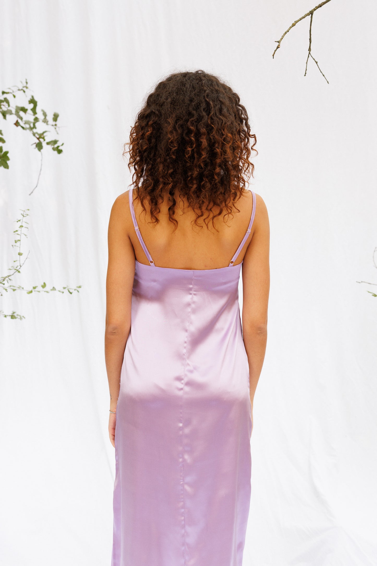 Back close image of Maria wearing purple slip dress